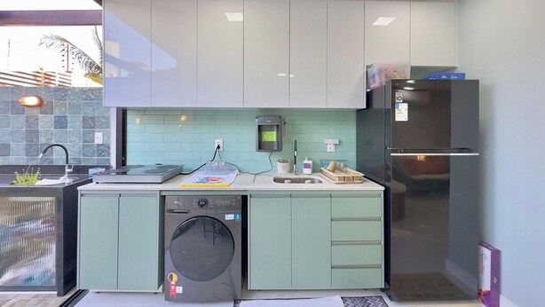 Una cucina moderna con lavatrice, frigorifero e forno integrato.