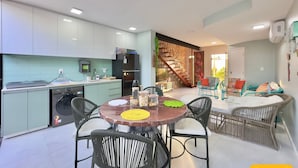 Una cocina moderna con comedor, una escalera y una sala de estar.