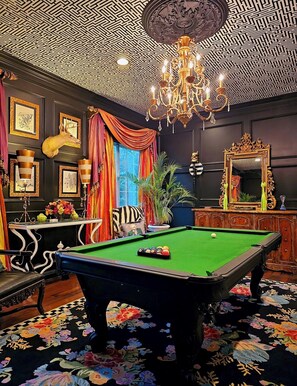 A billiards room with a green pool table, a chandelier, framed artwork, and a mirror. - Unique +Upscale +4 Bedroom (Shreveport)