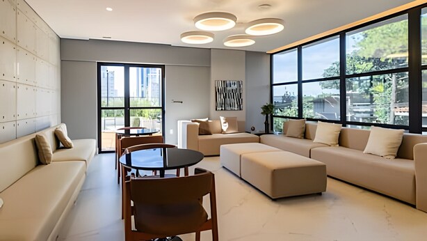 A modern living room with a sofa, ottoman, dining table, and chairs. Large windows provide natural light and views of the outdoors. - Smart Bourbon 304 (São Paulo)