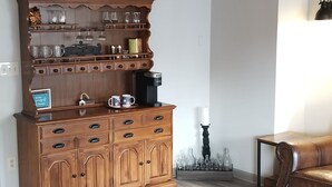 Ein Holzkabinett mit mehreren Regalen, Schubladen und einer Kaffeemaschine.