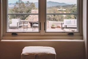 A window with a view of outdoor seating and a stone wall. - Near Santa Fe Plaza, Luxury Outdoor Space, Hot Tub (Santa Fe)