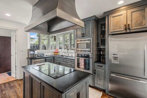 A modern kitchen with stainless steel appliances, a large island, and a view through the windows. - Near Santa Fe Plaza, Luxury Outdoor Space, Hot Tub (Santa Fe)