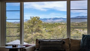 Ein Zimmer mit einem großen Fenster und Blick auf eine Berglandschaft.