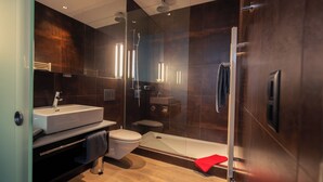 Ein modernes Badezimmer mit einer gläsernen Duschkabine, einem weißen Waschbecken und einer Badewanne.