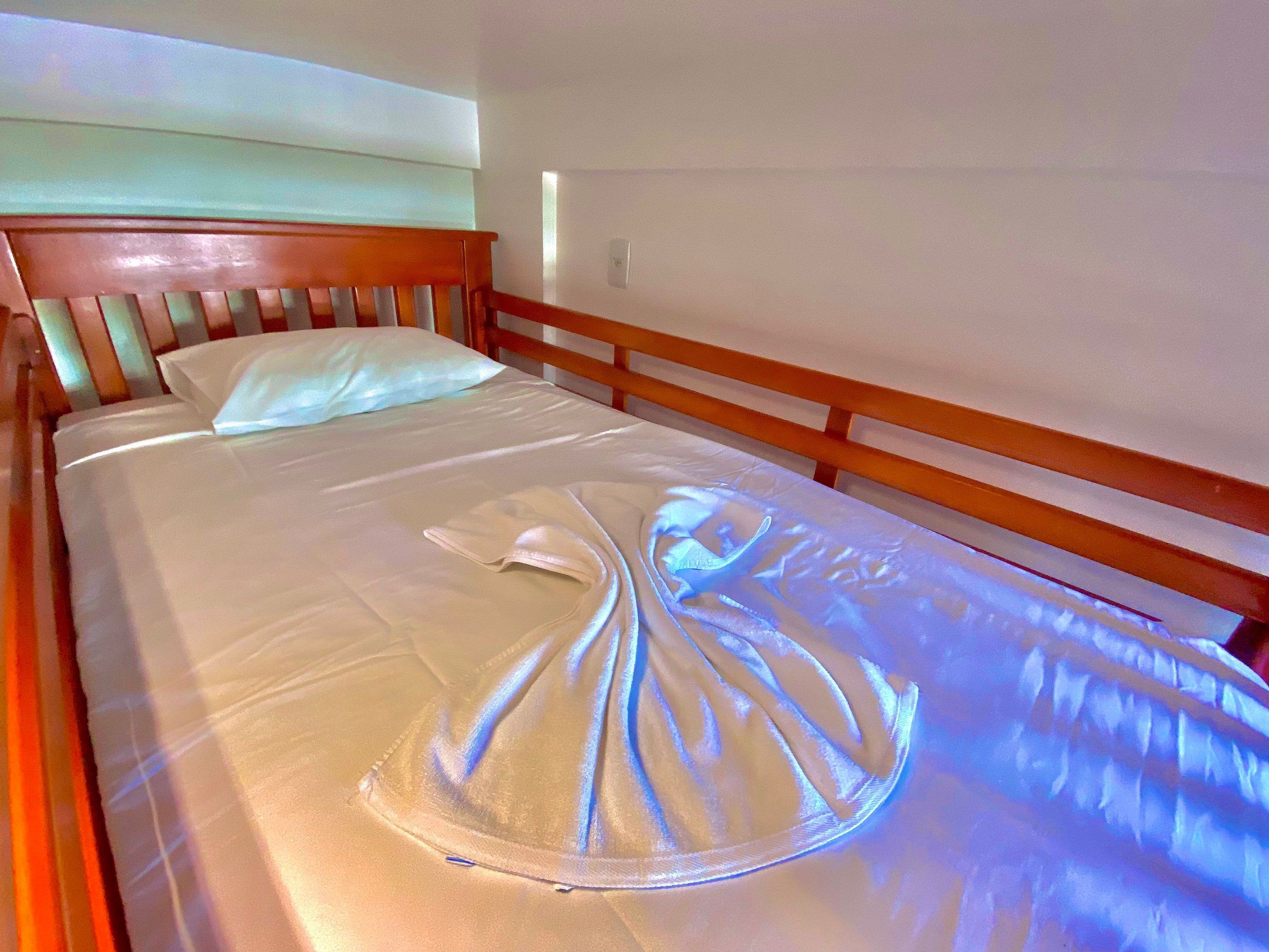Un lit avec un drap blanc et une couverture pliée.