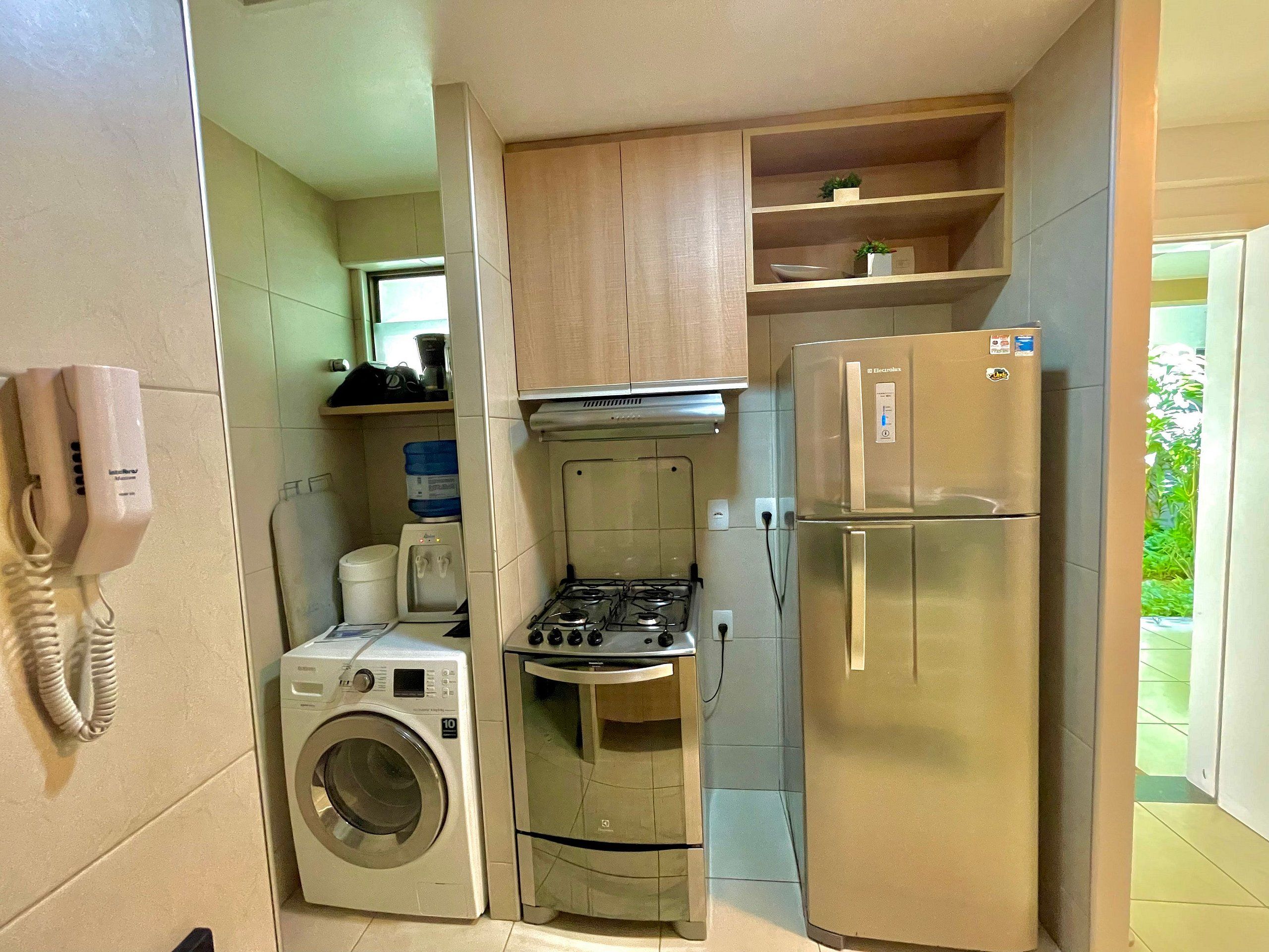 Eine kompakte Küche mit Waschmaschine, Herd und Kühlschrank.