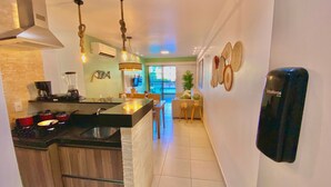 Una cocina moderna con una isla central, un comedor con vistas y una sala de estar con purificador de aire integrado.