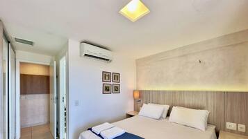 Ein Hotelzimmer mit Bett, Klimaanlage, Nachttischlampe und einer Tür zu einem Badezimmer.