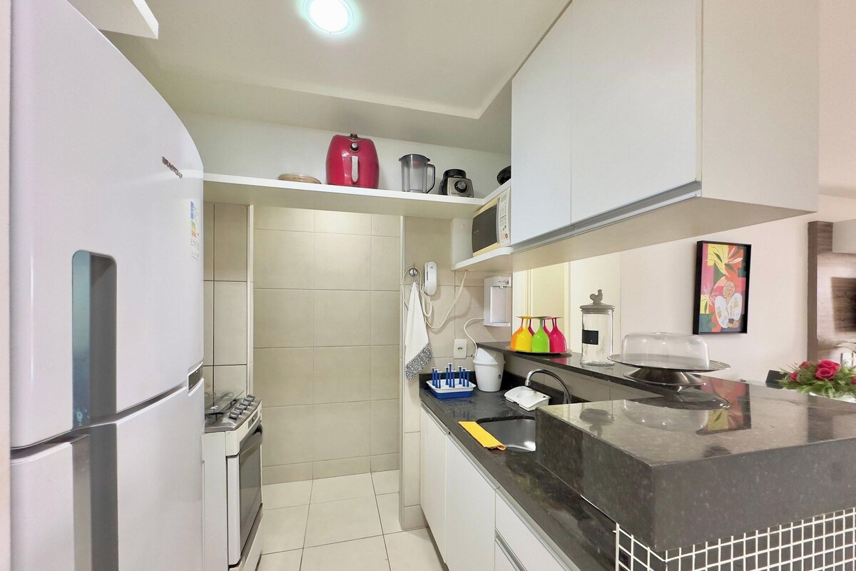 A modern kitchen with a refrigerator, stove, microwave, and a sink.