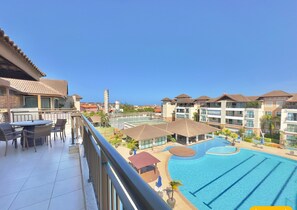 Un hotel con piscina, zona de estar al aire libre y vistas de los edificios circundantes.
