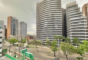 A modern high-rise building with multiple balconies and a curved facade.