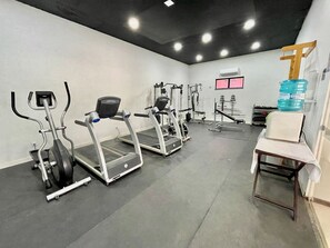 A gym with treadmills, elliptical machines, and weight equipment.