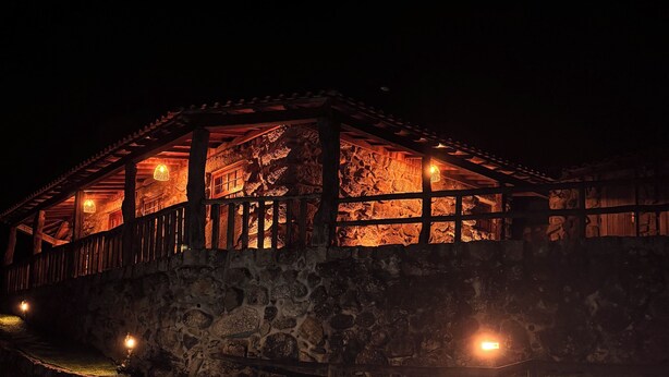 A stone building with a swimming pool at night.