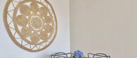 A dining area with a round table, chairs, and a wall-mounted decorative piece.
