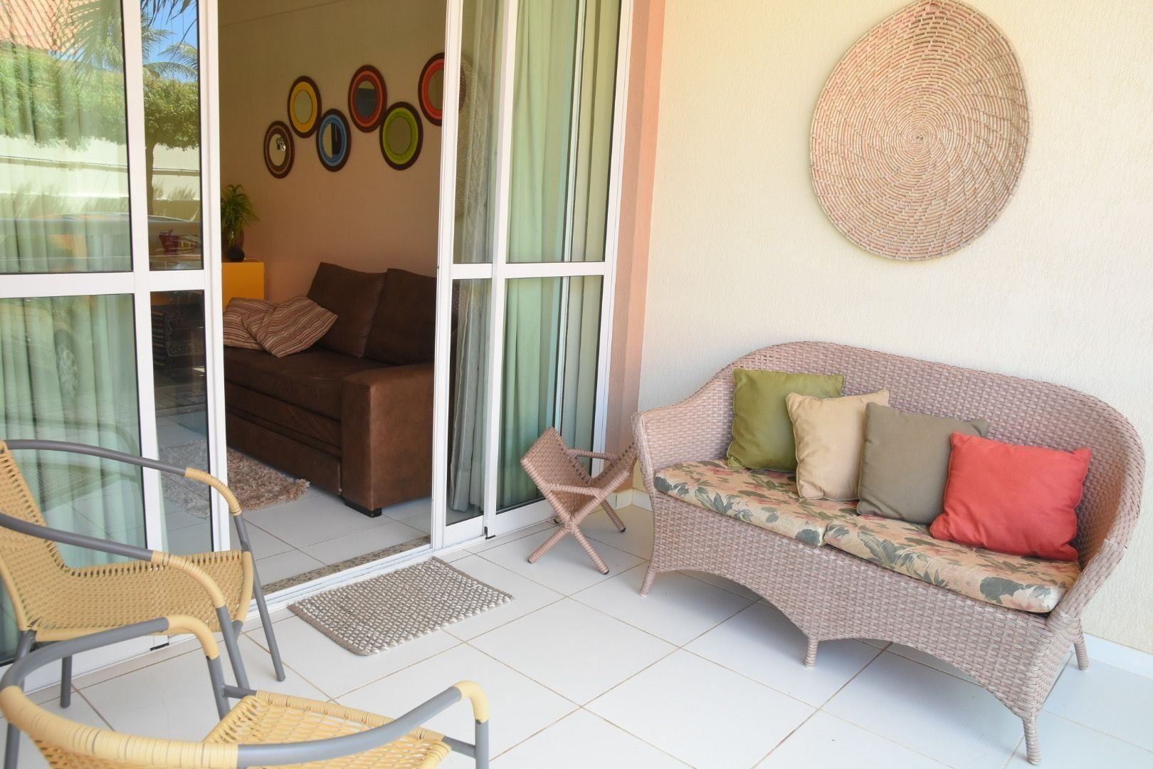 A living area with a sofa, chairs, a patterned wall, and a circular wall decoration.