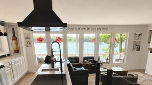 A modern kitchen with a central island, large windows with a view of the lake, and a cozy seating area.