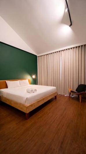 A hotel room with a bed, a chair, a lamp, and a window with curtains. - Centerpoint Koh Phangan (Ko Pha-ngan)