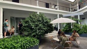 A multi-level outdoor area with seating and greenery, a covered seating area, and a building with balconies. - Centerpoint Koh Phangan (Ko Pha-ngan)