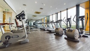 A modern gym with cardio machines, large windows, and a clean, spacious layout. - Skyline 3BR Duplex | Pool, Gym & Parking (Manchester)