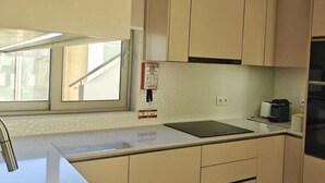 A kitchen with beige cabinets, a stainless steel sink, a window, and a black refrigerator. - 2 bedroom apartment 1 minute walk from Cortegaça beach - Refugio do Surf Cortegaça (Cortegaça)