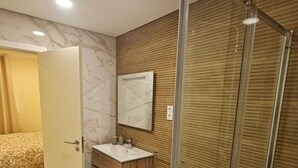 A modern bathroom with a glass shower enclosure, a marble floor, a wooden vanity, and a toilet. - 2 bedroom apartment 1 minute walk from Cortegaça beach - Refugio do Surf Cortegaça (Cortegaça)