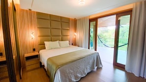 Ein modernes Schlafzimmer mit einem großen Bett, einem hölzernen Kopfteil, einem Nachttisch und Blick auf einen Balkon.