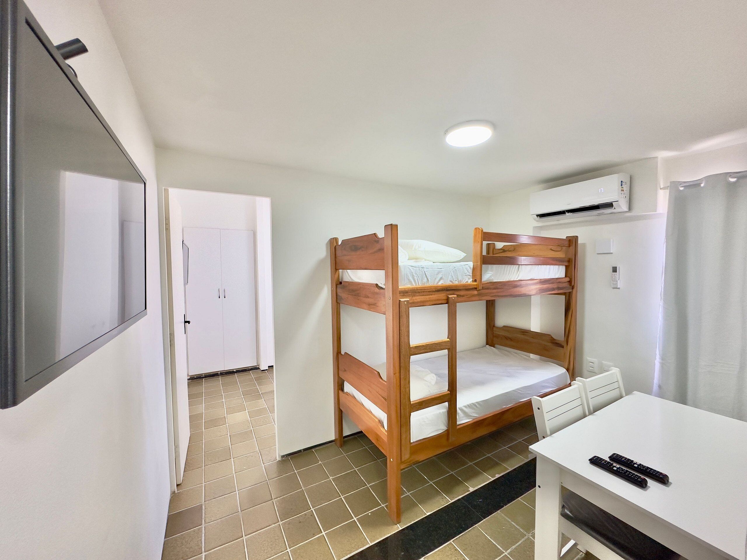 A bunk bed room with a desk and two remote controls.