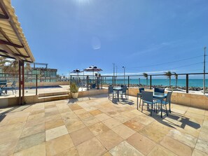 A terrace with outdoor seating, a pool, and a view of the ocean. - Flats Tabajara Residence (Fortaleza)