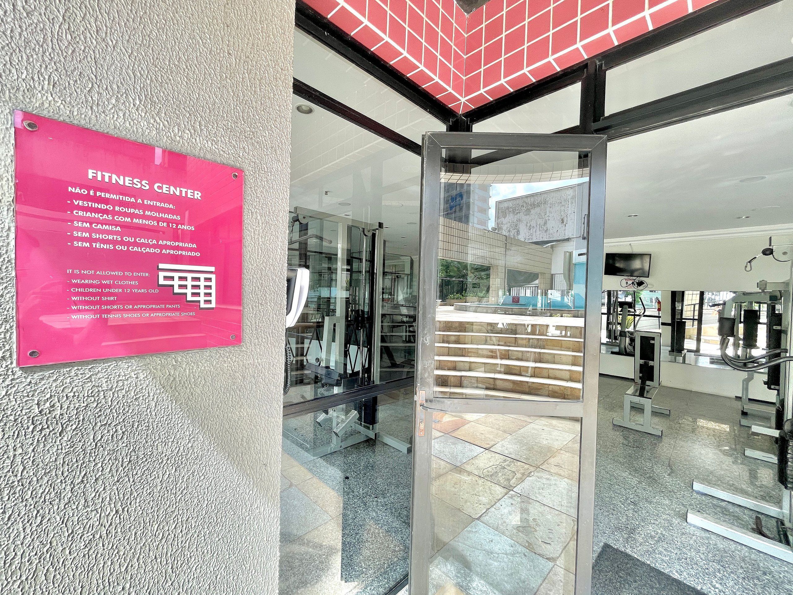 A fitness center entrance with a sign listing entry restrictions.