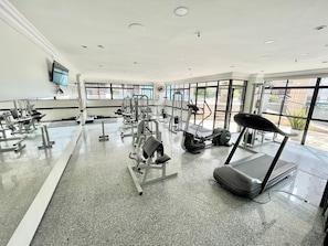 A gym with various exercise equipment, large windows, and a flat floor. - Flat no Saint Martin (Fortaleza)
