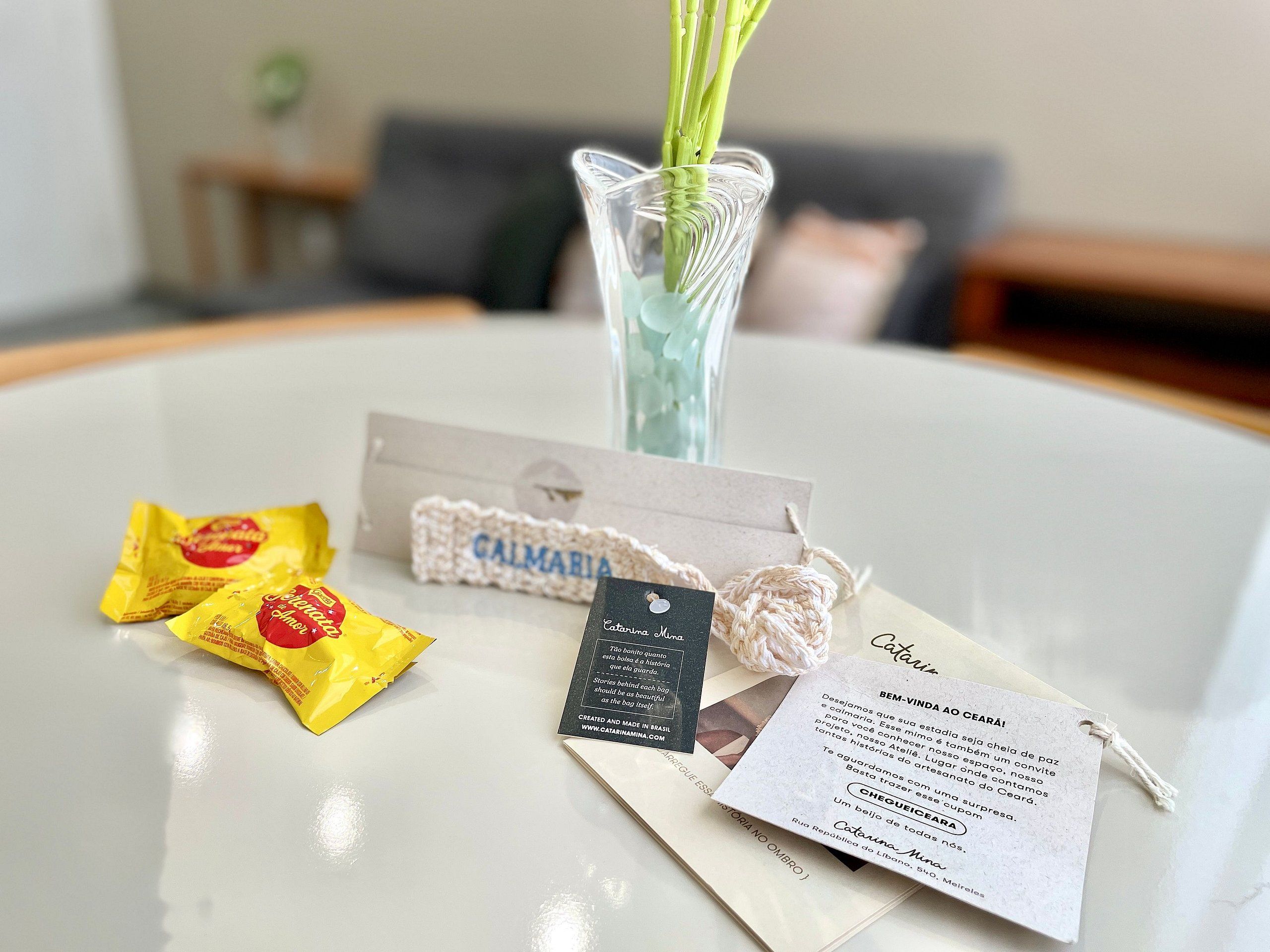 A table with a vase, a card, and two yellow packages.