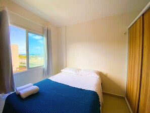 A hotel room with a bed, a window with curtains, and a view of the outside. - VG Fun Praia do Futuro - CE (Fortaleza)