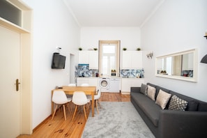 A compact living space with a dining area, kitchen, and seating area. - Large 3-Bedroom 2 Bathroom Apartment, Multiple Bathrooms, Prime Lisbon Location (Lisboa)