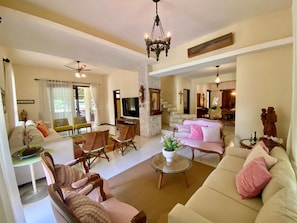 A spacious living room with a sofa, chairs, a coffee table, and a TV.
