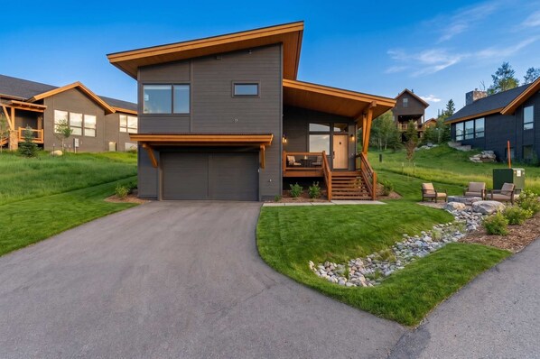 A modern two-story house with a garage, a covered porch, and a well-maintained lawn. - Summit County Gem |  Designer Kitchen + Great Views (Silverthorne)