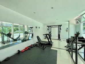 Una palestra con attrezzature per esercizi, una panca e manubri.