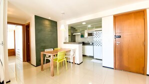 Una cucina moderna con zona pranzo, un forno a microonde e un frigorifero.