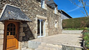 A stone building with a wooden door and a window. - Country house 10 minutes from Saint-Jacut-de-la-mer (Corseul)
