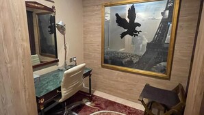 A room with a desk, chair, lamp, and a large framed picture of an eagle.