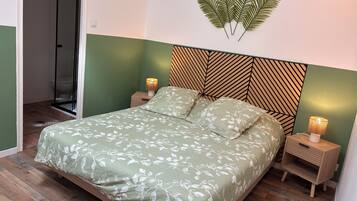 Una camera da letto con un letto, comodini, una lampada a parete e un angolo doccia.