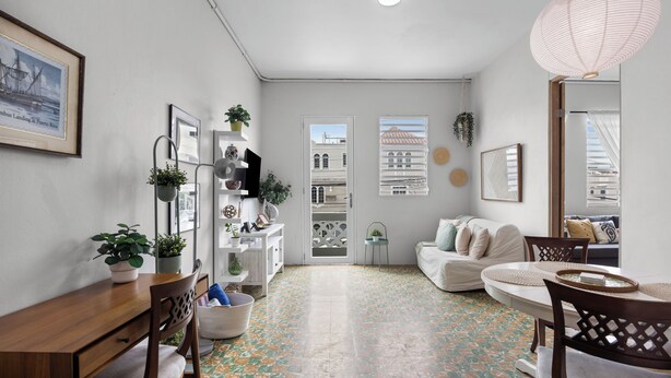 A modern living room with a dining area, a sofa set, a wooden table, and a patterned floor.