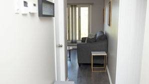 Un pasillo con un banco, un sofá y una puerta que da a una habitación.