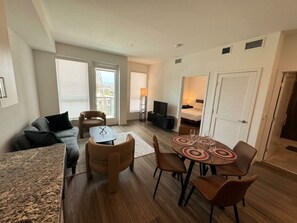 A modern living room with a sofa, chairs, a dining table, and a TV. - Monthly Stays 1BR Near CSUN w/ Free Parking & Laundry (Los Angeles)