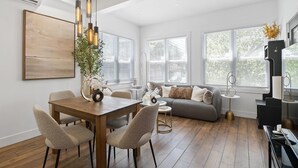 Un soggiorno moderno con zona pranzo, ampie finestre e un design minimalista.