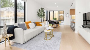 Una sala de estar moderna con un sofá, una mesa de centro y un comedor con sillas y una mesa.