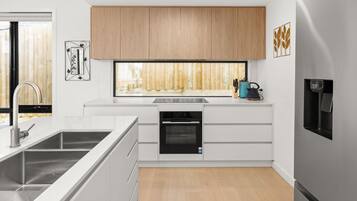 A modern kitchen with a built-in dishwasher, a large window, and a water dispenser.