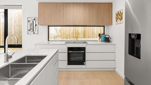 A modern kitchen with a built-in dishwasher, a large window, and a water dispenser. - Fleetwood Atelier Pet Friendly in Frankston South (Frankston South)