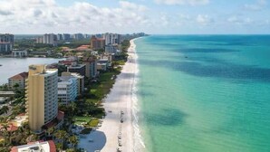 Paesaggio costiero con spiaggia, edifici a grattacielo e vista chiara sull'oceano.