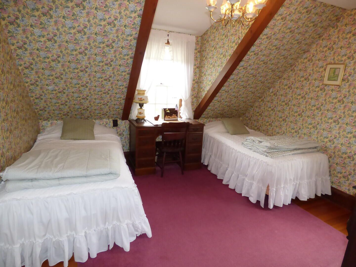 Une chambre avec deux lits, un bureau et une chaise.